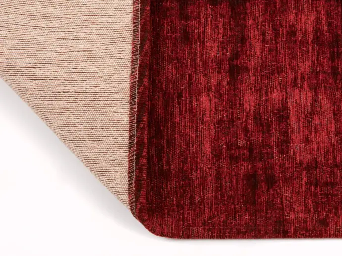 Nahaufnahme des Vintageteppichs Saragoza in Farbe rot, mit umgeschlagener Ecke, welches den Rücken zeigt.