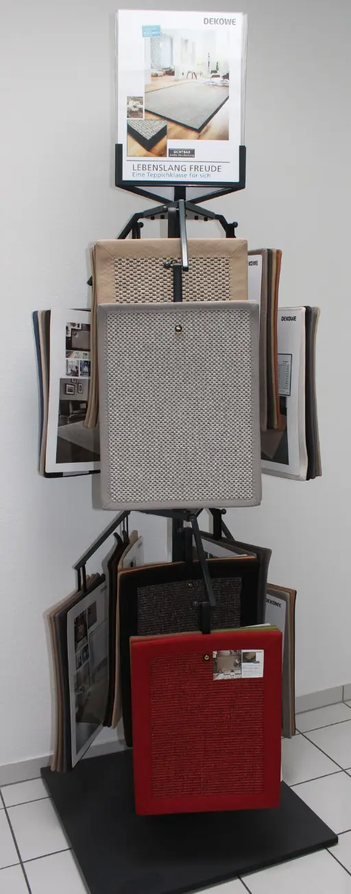 Foto eines Drehständers mit Mustern von Bordürenteppichen und Top-Schild.